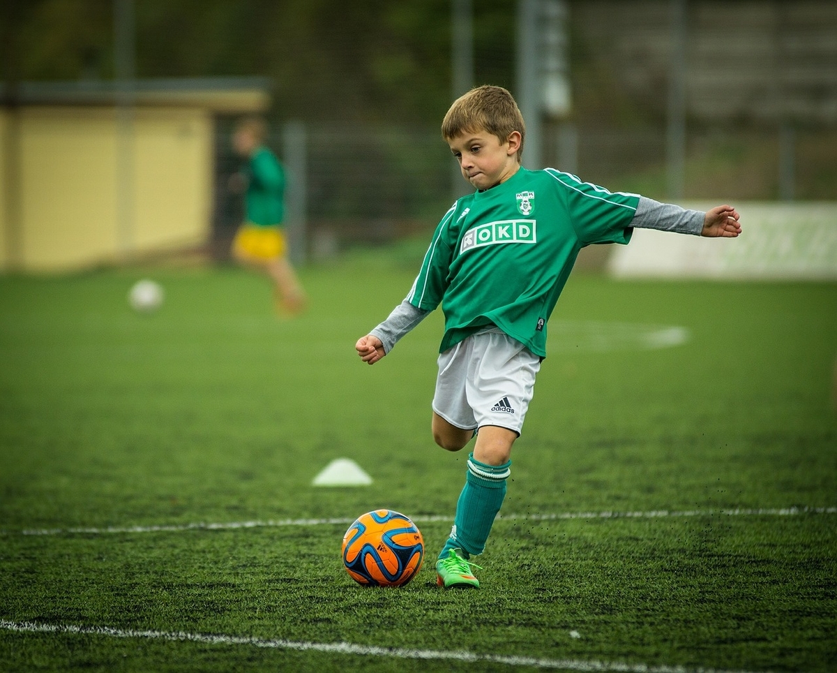 サッカーボールを踏む少年の後ろ姿